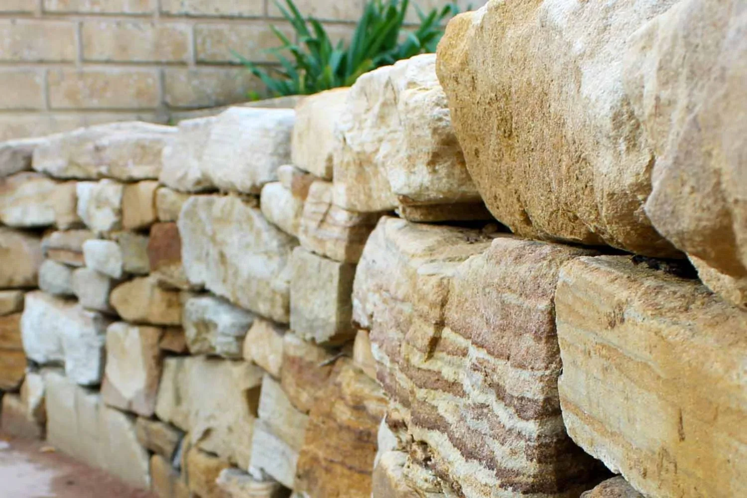 Close-up of stacked natural sandstone boulders in a retaining wall